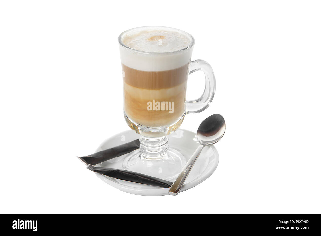 Kaffee mit Milch, Kakao, Schokolade, in einem hohen Glas auf einer Platte mit einem schwarzen Zucker Pakete und einen Teelöffel. Von der Seite. Isoliert weißer backgrou Stockfoto
