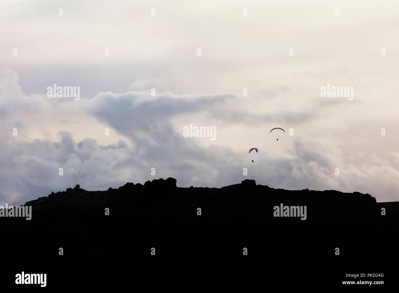 Zwei Gleitschirme über Chinkwell Tor im Nationalpark Dartmoor, Devon Stockfoto