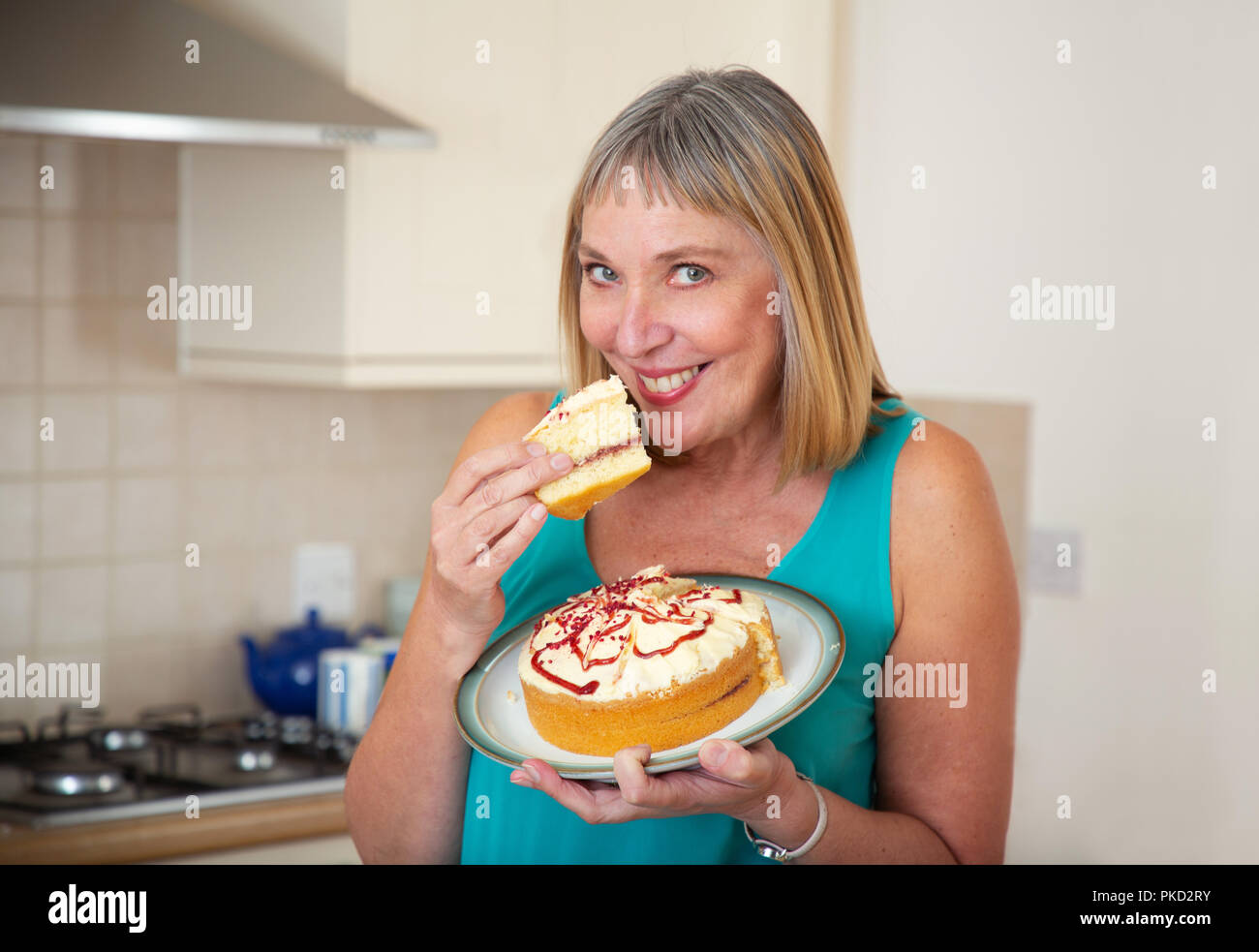Frau essen eine Creme Biskuitteig Stockfoto