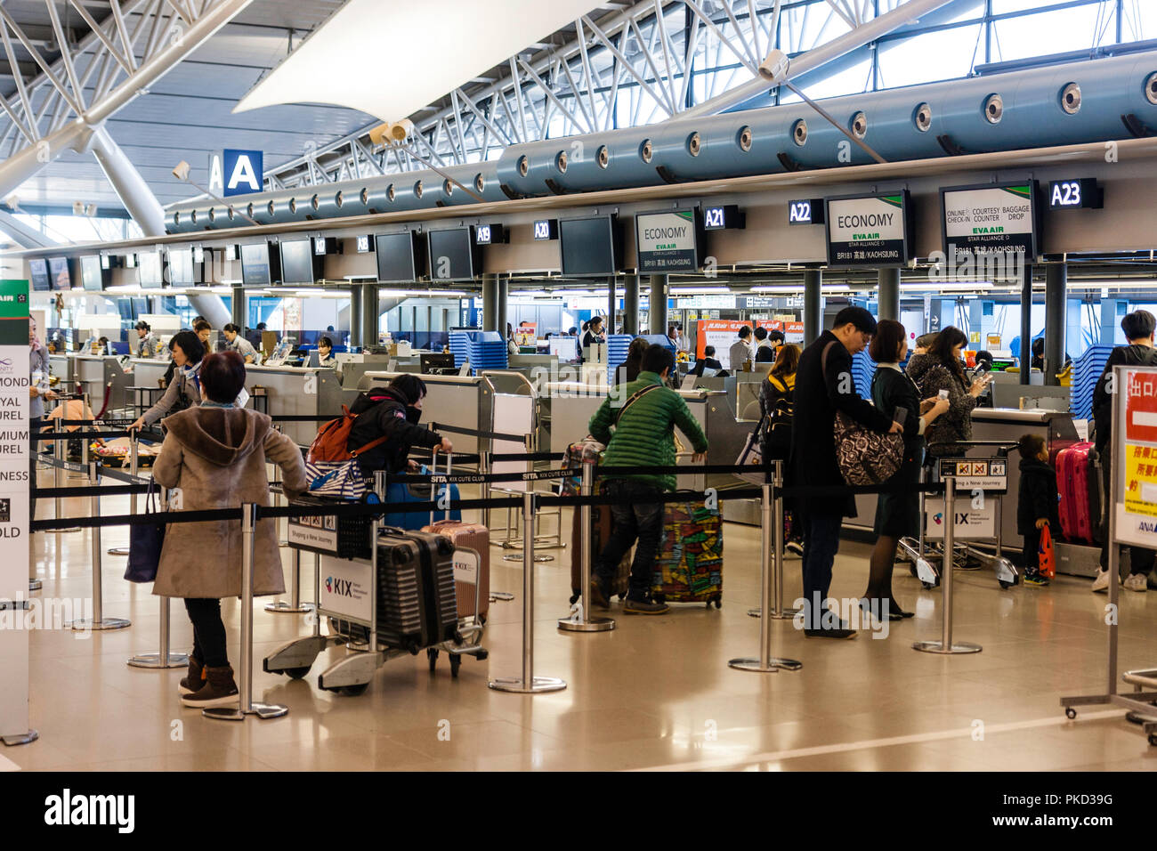 Japan, Osaka. Kansai International Airport. KIX, Terminal 1, 4. Stock internationale Abflüge. Personen mit Gepäck am Check-in-Schaltern. Stockfoto