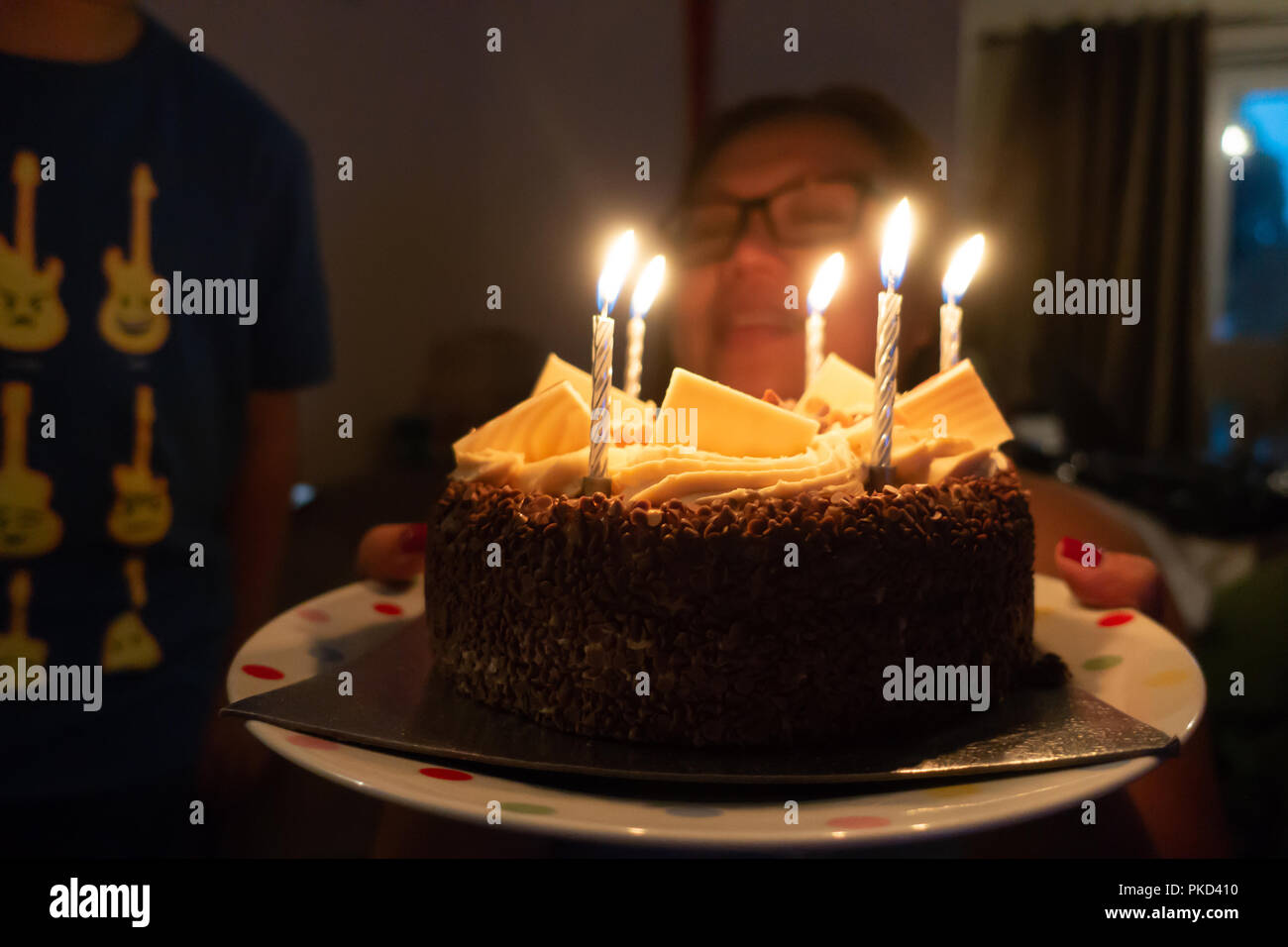 Eine Nahaufnahme einer Schokolade Kuchen hat Geburtstag Kerzen brennen auf der Oberseite. Stockfoto