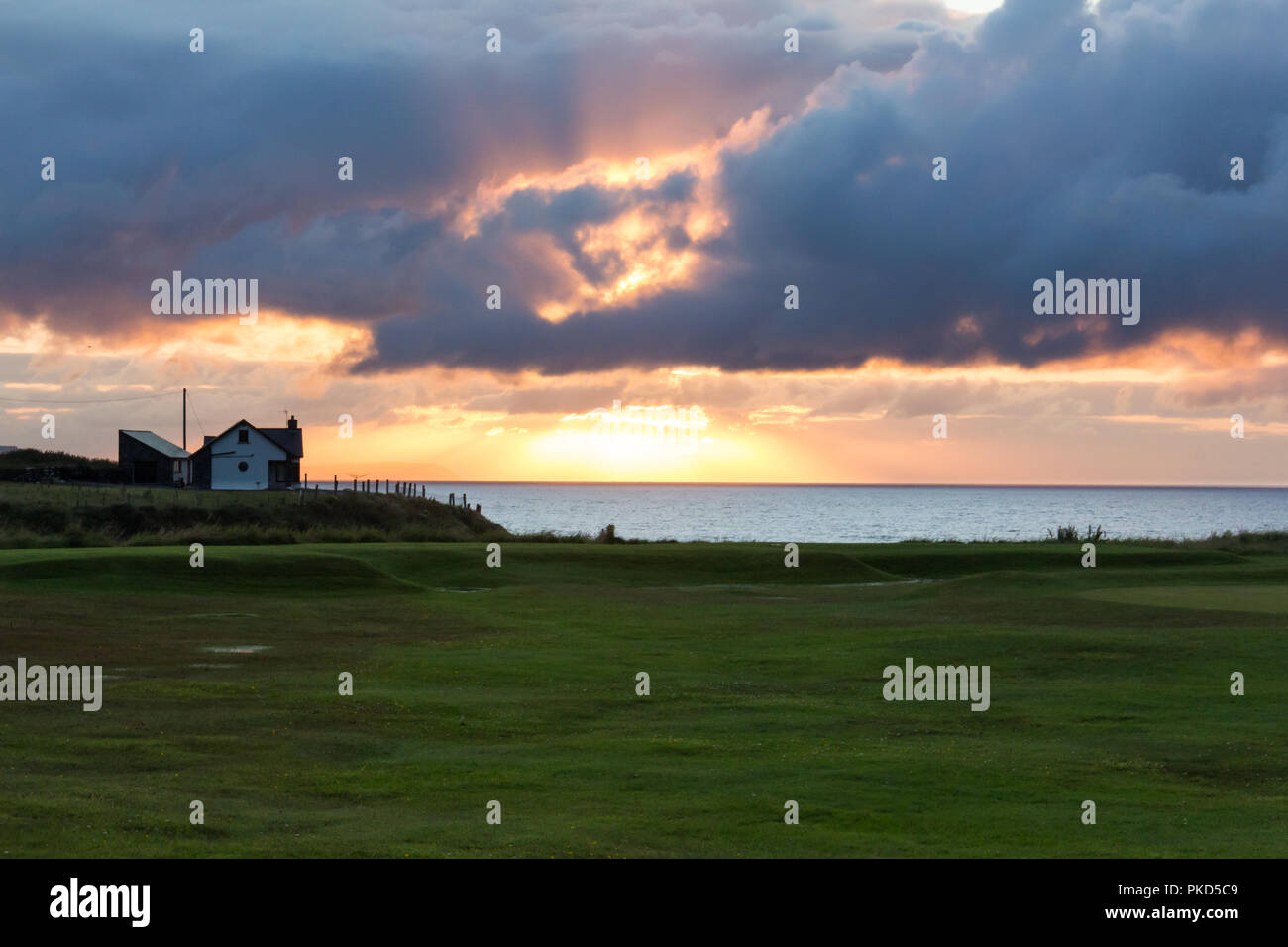 Sonnenuntergang brechen durch dunkle Wolken über der Nord Antrim Coast, Portstewart, N. Irland. Stockfoto