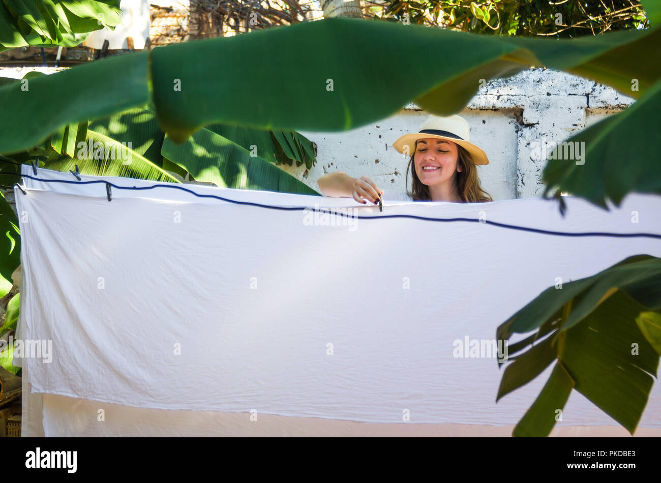 Girl hängende Blätter, die auf einer Wäscheleine im Freien Stockfoto