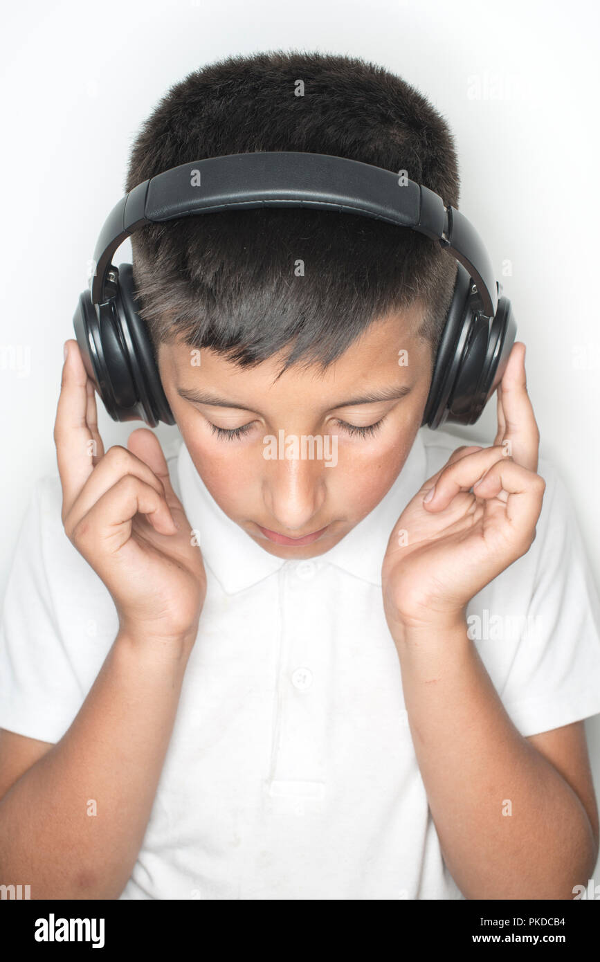 Junge, 10 Jahre alt, hört Musik über Kopfhörer Stockfoto