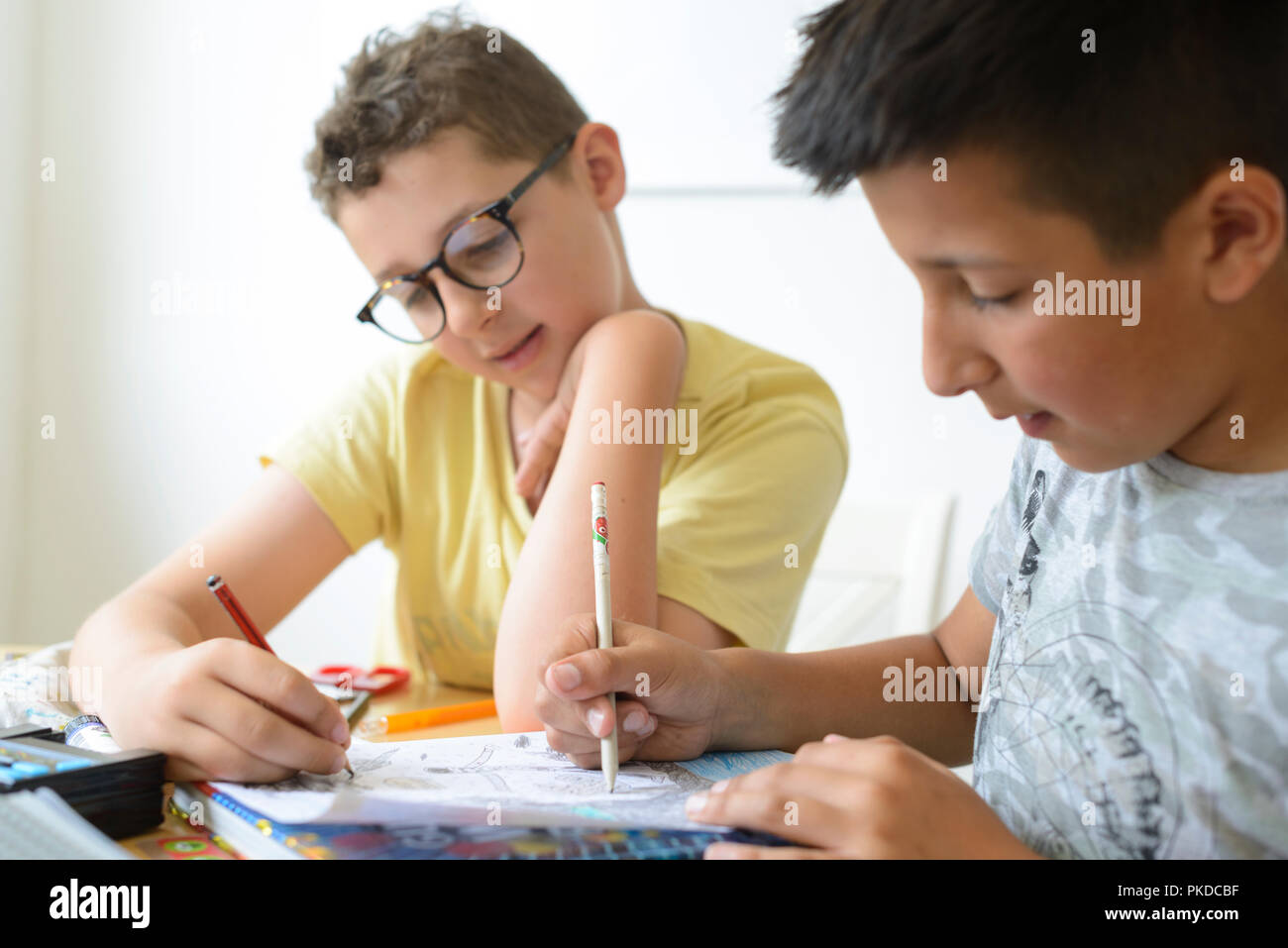 UK-Boy hilft seinem Schulfreund mit Mathe Hausaufgaben Stockfoto
