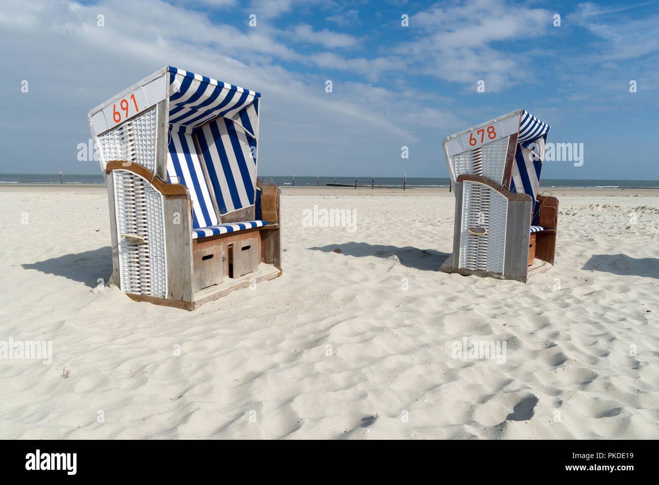 Zwei Strandkörben an der Küste der Insel Norderney vor dem Ozean. Großem Betrachtungswinkel Stockfoto