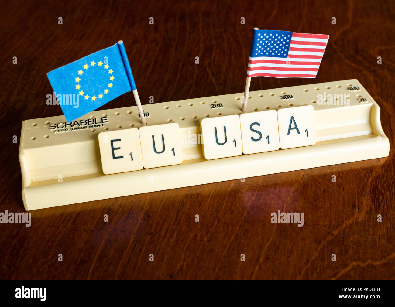 Scrabble Buchstaben Rechtschreibung EU und USA mit Amerikanischen und Europäischen Union Flaggen auf Mahagoni Hintergrund Nation, Handel und Verhandlung Konzept zu veranschaulichen Stockfoto