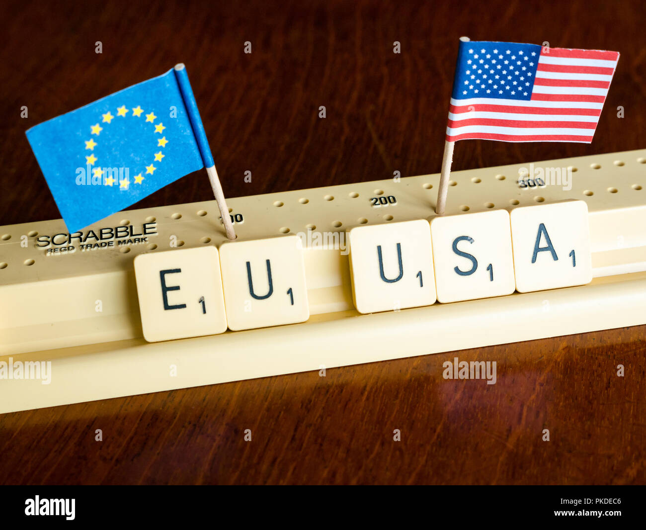 Scrabble Buchstaben Rechtschreibung EU und USA mit Amerikanischen und Europäischen Union Flaggen auf Mahagoni Hintergrund Nation, Handel und Verhandlung Konzept zu veranschaulichen Stockfoto