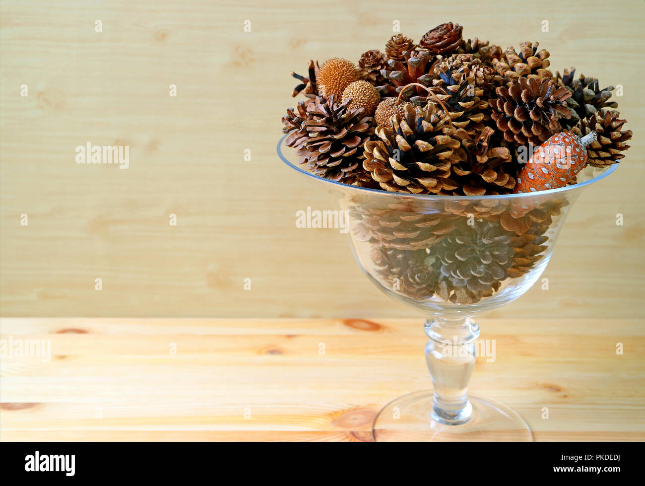 Klares Glas Kompott voller verschiedener Art und Größe der natürlichen trockene Tannenzapfen auf hölzernen Hintergrund, mit Freiraum für Text oder Design Stockfoto