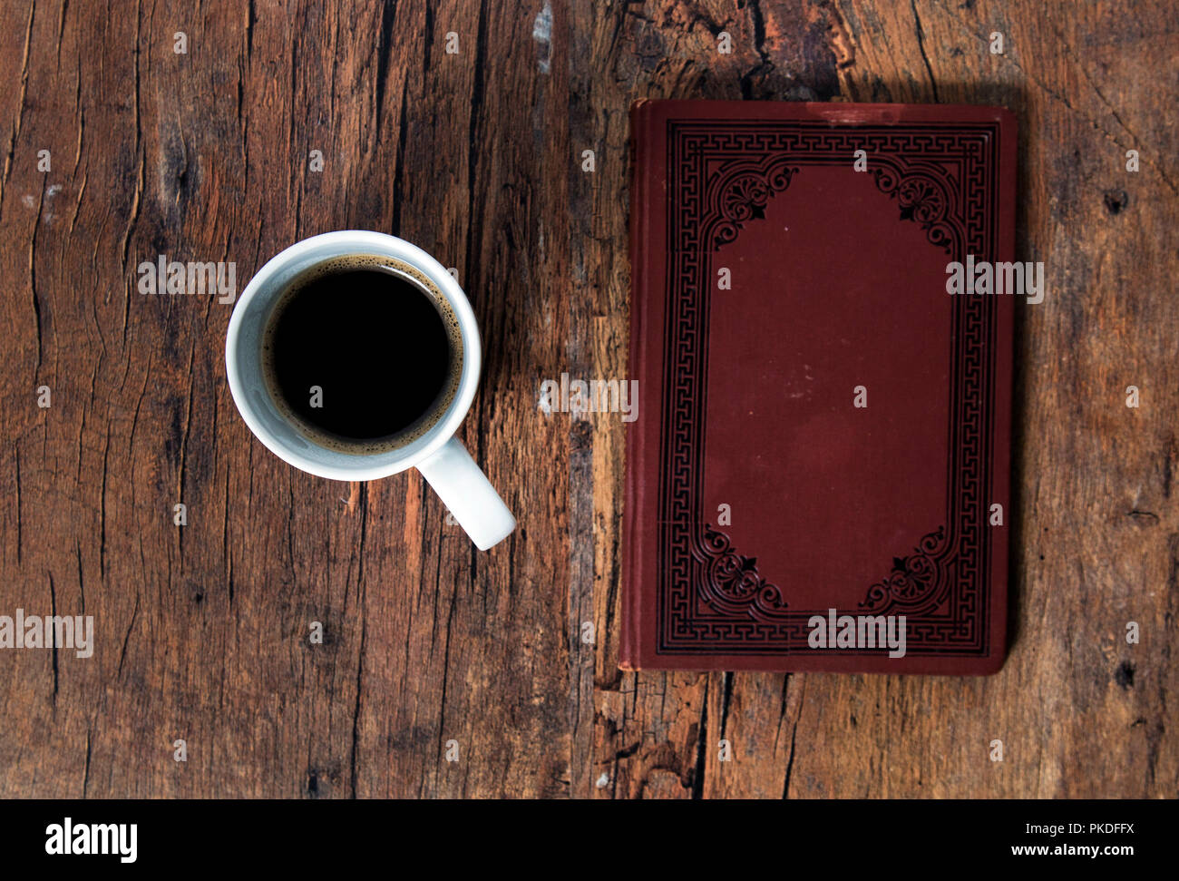 Kaffeetasse und altes Buch auf dem hölzernen Tisch Stockfoto
