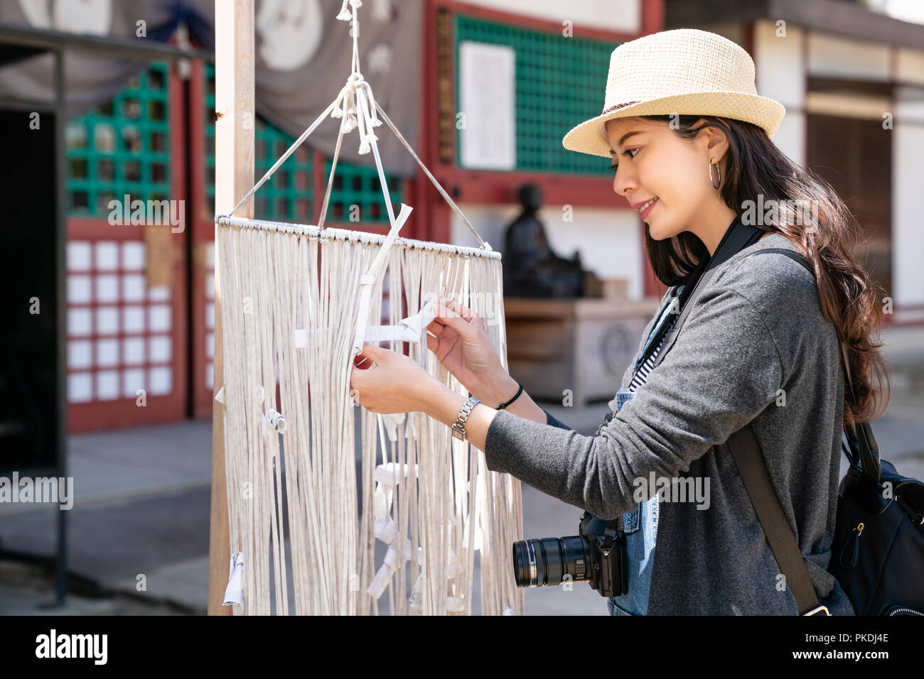 Ziemlich asain Besucher Binden der japanischen fortune Papier auf Seilen und wollen eine gute Fülle. Stockfoto