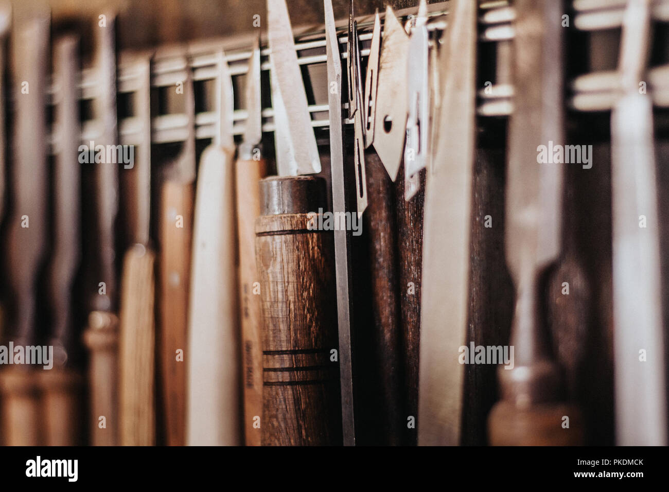 Extreme Nahaufnahmen von hängenden Tools innerhalb Woodshop. Zimmerei leben, Stahlklingen, Bohren Zubehör, Holz- griffe, und Griffe. Florenz, Italien Stockfoto