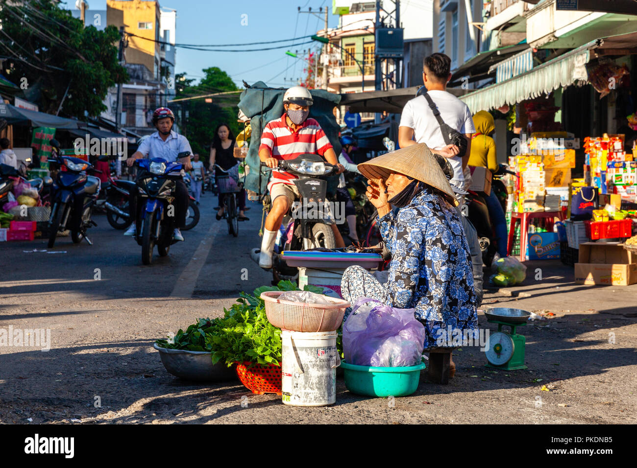 NHA TRANG, VIETNAM - AUGUST 06: Eine ältere Frau verkauft Grün am Street Market am August 06, 2018 in Nha Trang, Vietnam. Stockfoto