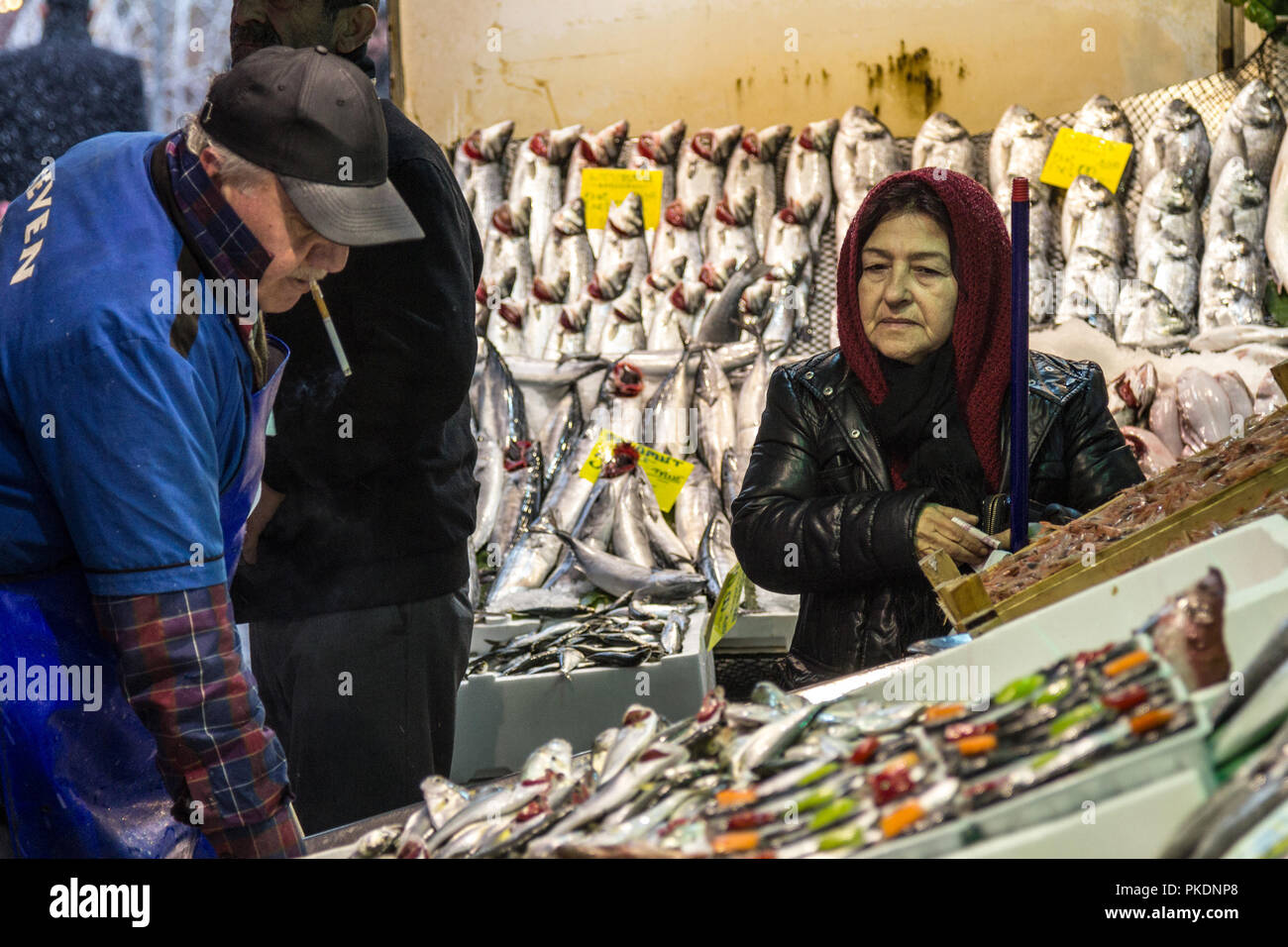 ISTANBUL, Türkei - 30. Dezember 2015: Alte Frau das Tragen des islamischen Schal kaufen Fisch in der Fischmarkt von Kadiköy auf der asiatischen Seite. Fische in der ma Stockfoto