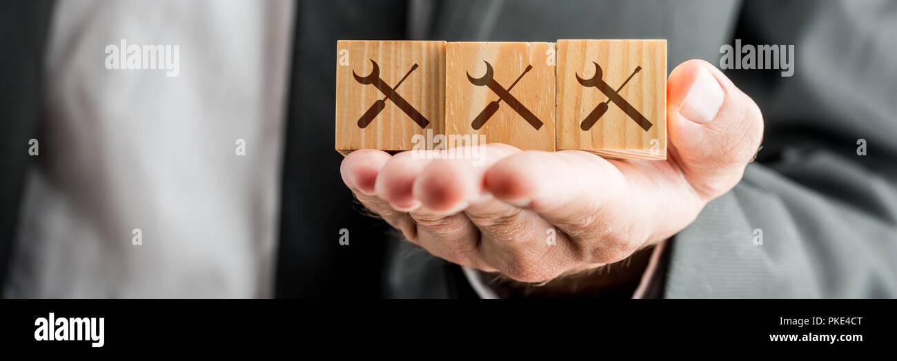 Close up Konzeptuelle Geschäftsmann, Holzklötze auf seiner Hand mit Service Tools Drucke. Stockfoto