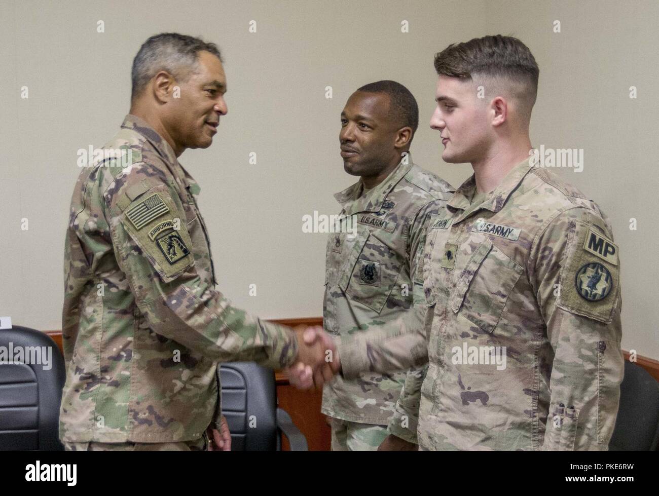 Generalleutnant Michael X. Garrett, US-Army Central kommandierender General, gratuliert Spc. Zachary Johnson, der 202 Military Police Company im Camp als Saliyah, Katar, 26. Juli 2018 zugewiesen. Generalleutnant Garrett präsentiert Adkins mit einer Münze für seine Bemühungen, Mentoring und seine Kollegen unterstützen, und für das Erreichen einer perfekten Punktzahl auf der Armee körperliche Fitness testen. Stockfoto