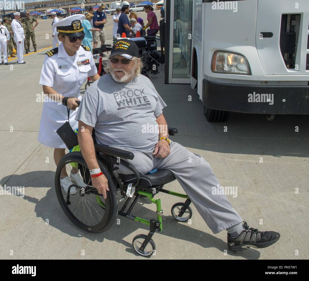 FARGO, N.D. (27. Juli, 2018) Leutnant Alana Kershner, Naval Supply System Befehl Fleet Logistics Center Bahrain zugeordnet, unterstützt Veteran Harvey Blaskowski den Sitz für die US-Navy Flight Demonstration Squadron, die Blue Angels, Praxis Demonstration während Fargo Marine Woche finden. Die Marine von Community Outreach verwendet die Navy Woche Programm Navy Sailors, Ausrüstung mitbringen und zeigt auf etwa 14 amerikanischen Städten jedes Jahr für eine Woche - lange Zeitplan von outreach Engagements für Amerikaner ausgelegt, aus erster Hand, wie die US-Marine ist die Marine die Nation braucht Erfahrung. Stockfoto