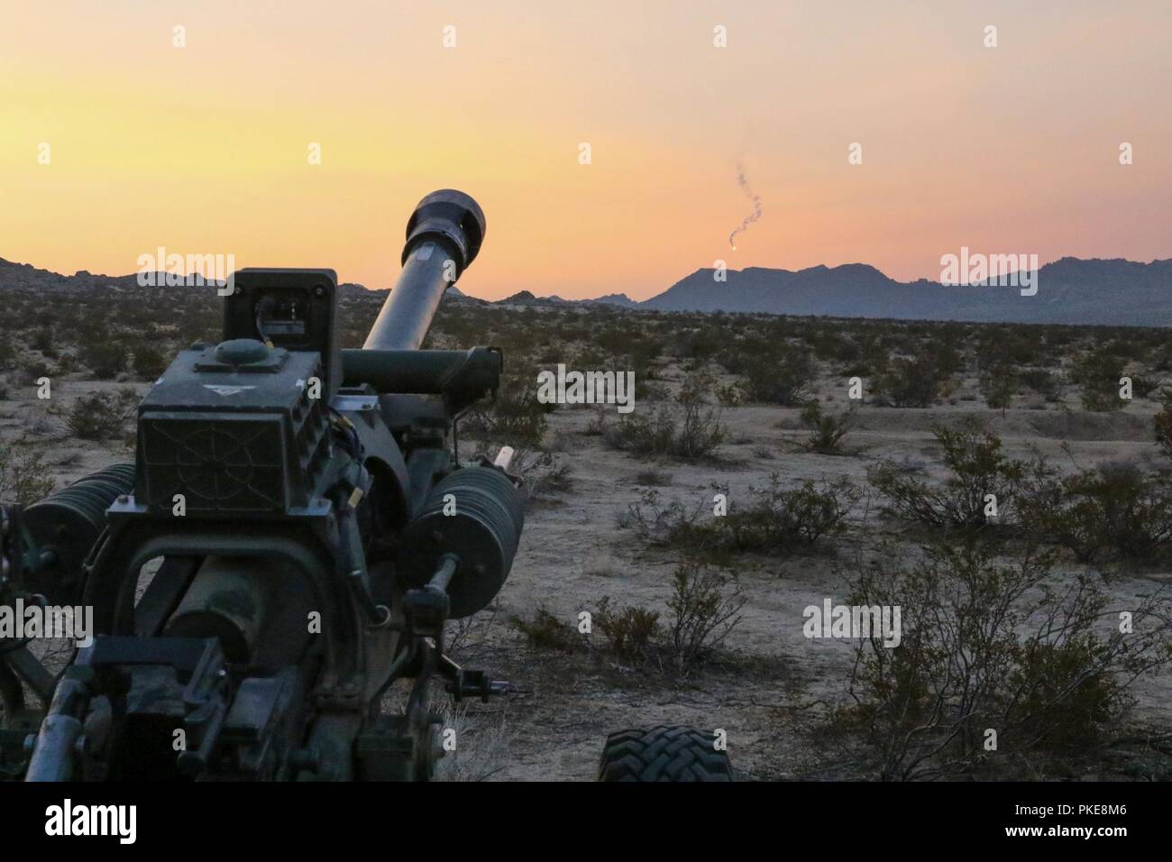 Eine Beleuchtung runden vom 2 Bataillon abgefeuert, 218. das Feld Artillerie M119 Haubitze setzt mit der Sonne Juli 27, 2018 Während ein Feld Training als exportierbar Combat Training (XCTC) in Fort Irwin, Kalifornien bekannt. Die Übung ist ein radlager Brigade Feld Training konzipiert Platoon Kenntnisse über die Feuerwehr in Abstimmung mit der ersten Armee zu zertifizieren. "Diese Übung hält unsere Einheiten ausgebildet und bereit für Missionen und baut auf der Ausbildung des Brigade aus dem letzten Jahr Warfighter Übung", sagte Oberst Eric Riley, Kommandant der 41 IBCT. Stockfoto
