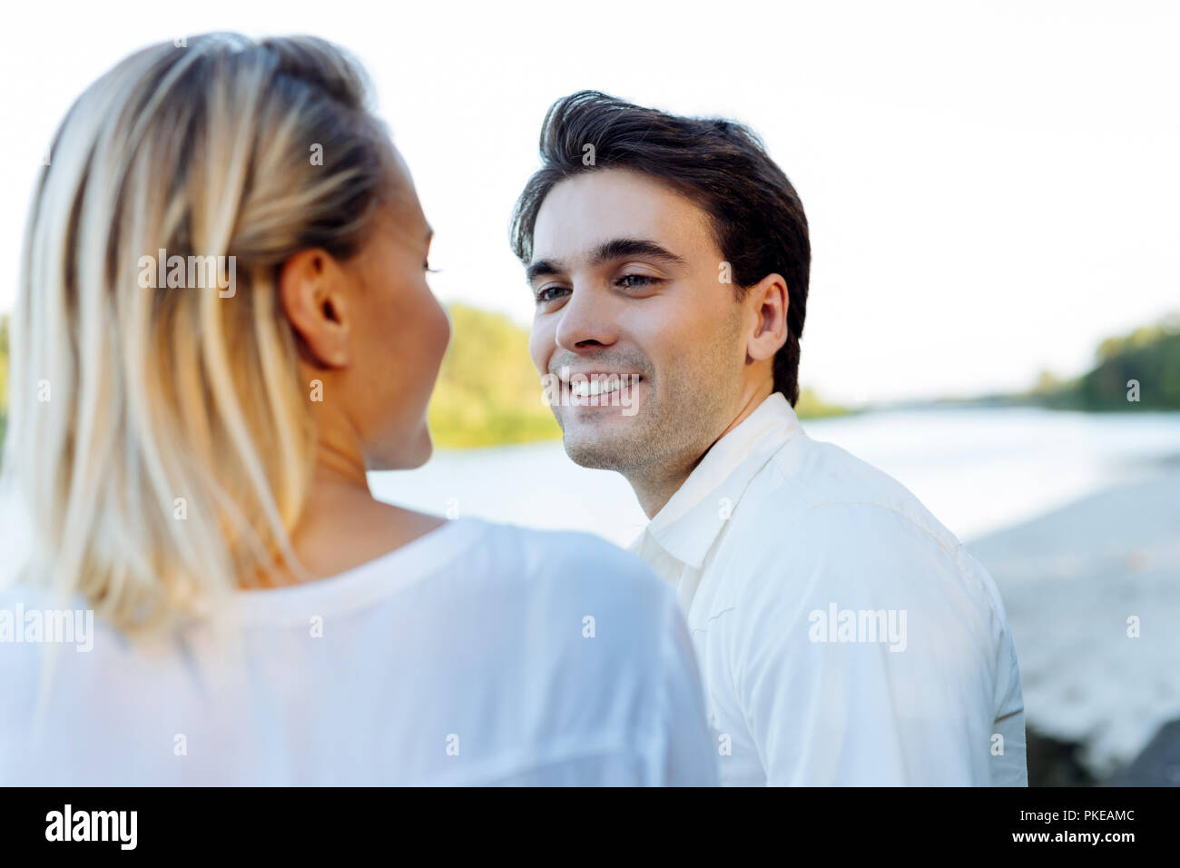 Fröhlicher schöner Mann lächelnd zu seiner Frau Stockfoto