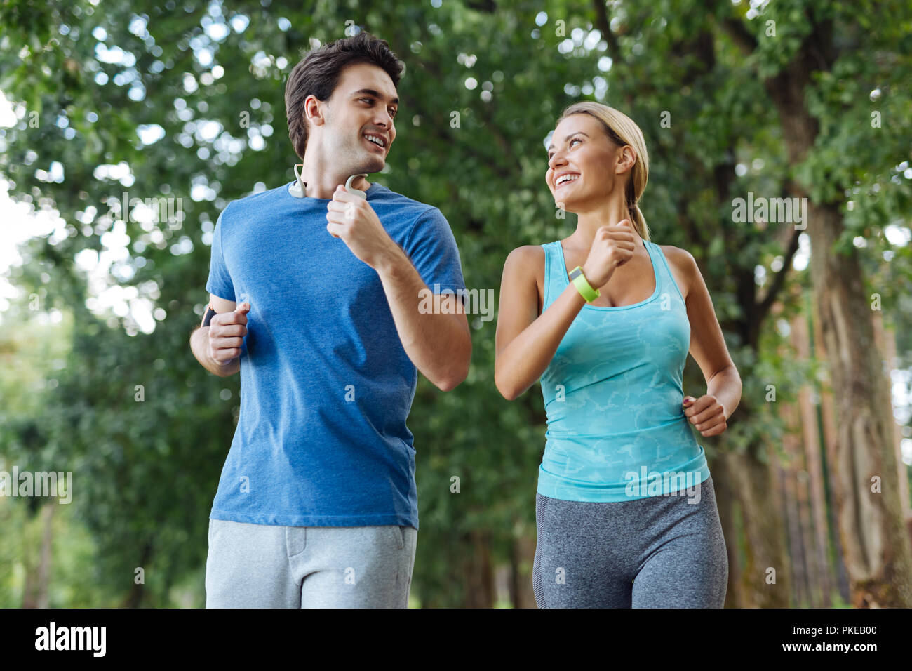 Schönes gesundes Paar joggen zusammen in den Wald Stockfoto