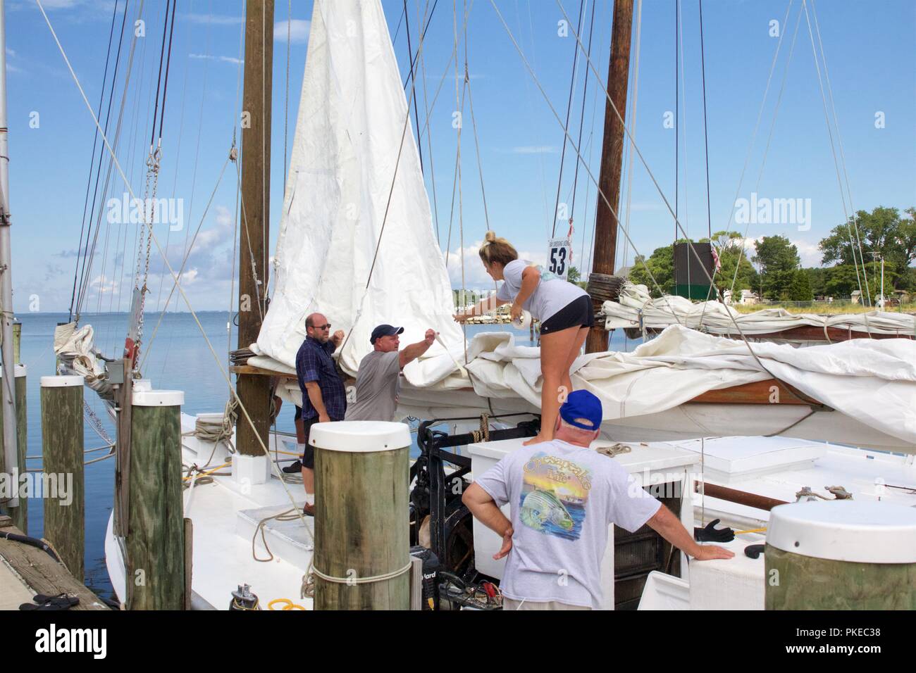 Deal Island, Maryland, USA - September 2, 2018: bootsfahrer Reparaturen auf ein Segel vor der jährlichen Angebot Insel Skipjack Rennen und Festival. Stockfoto