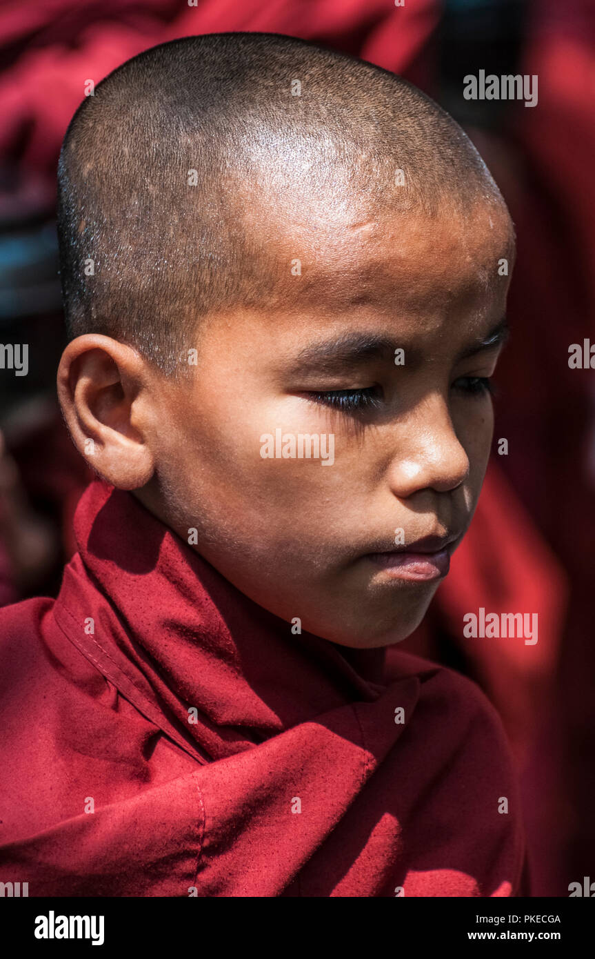 Ein junger Mönch warten auf Frühstück, Yangon, Myanmar Stockfoto