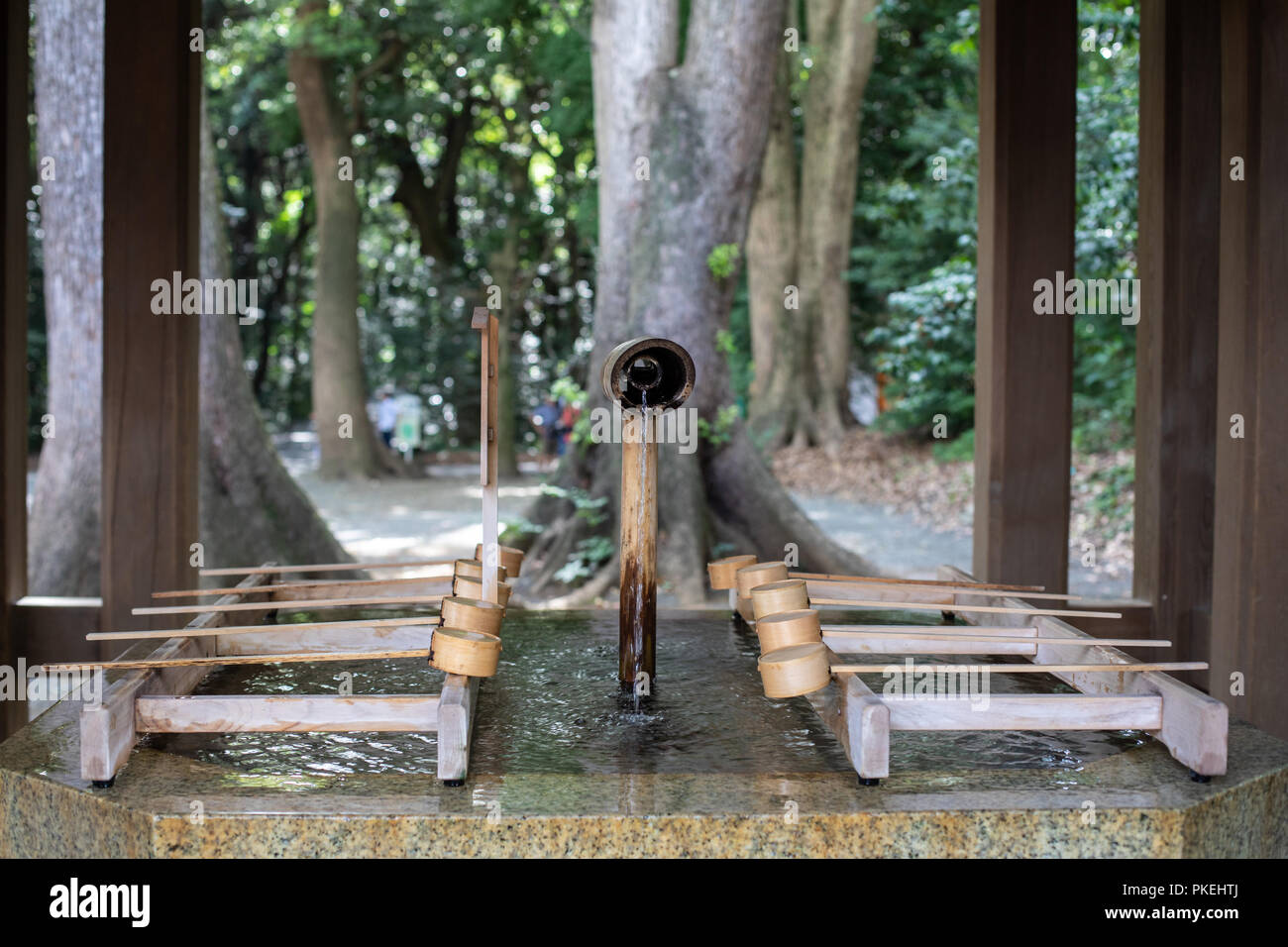 Ein Brunnen mit Bambus Schöpfkellen für rituelle Reinigung vor dem Betreten der Meiji Schrein in Tokio Stockfoto