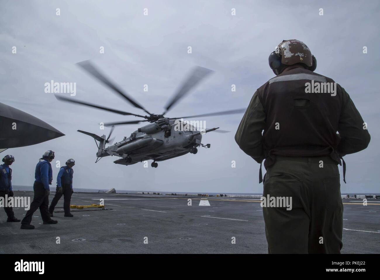 MINDANAO MEER - U.S. Navy Segler mit der Essex Amphibious Ready Group (ARG) und Marines mit dem 13 Marine Expeditionary Unit (MEU) bereiten Sie eine CH-53E Super Stallion mit Marine Medium Tiltrotor Squadron 166 verstärkt, 13. MEU, für Abflug an Bord der Wasp-Klasse amphibisches Schiff USS Essex (LL 2) während der Durchführung von Such- und Rettungsaktionen während einer planmäßigen Einsatz der Essex ARG und 13. MEU, 11. August 2018. Das Essex ARG/13 MEU ist derzeit auf dem Siebten Flotte Bereich der Operationen eingesetzt. (U. Us Marine Corps Stockfoto