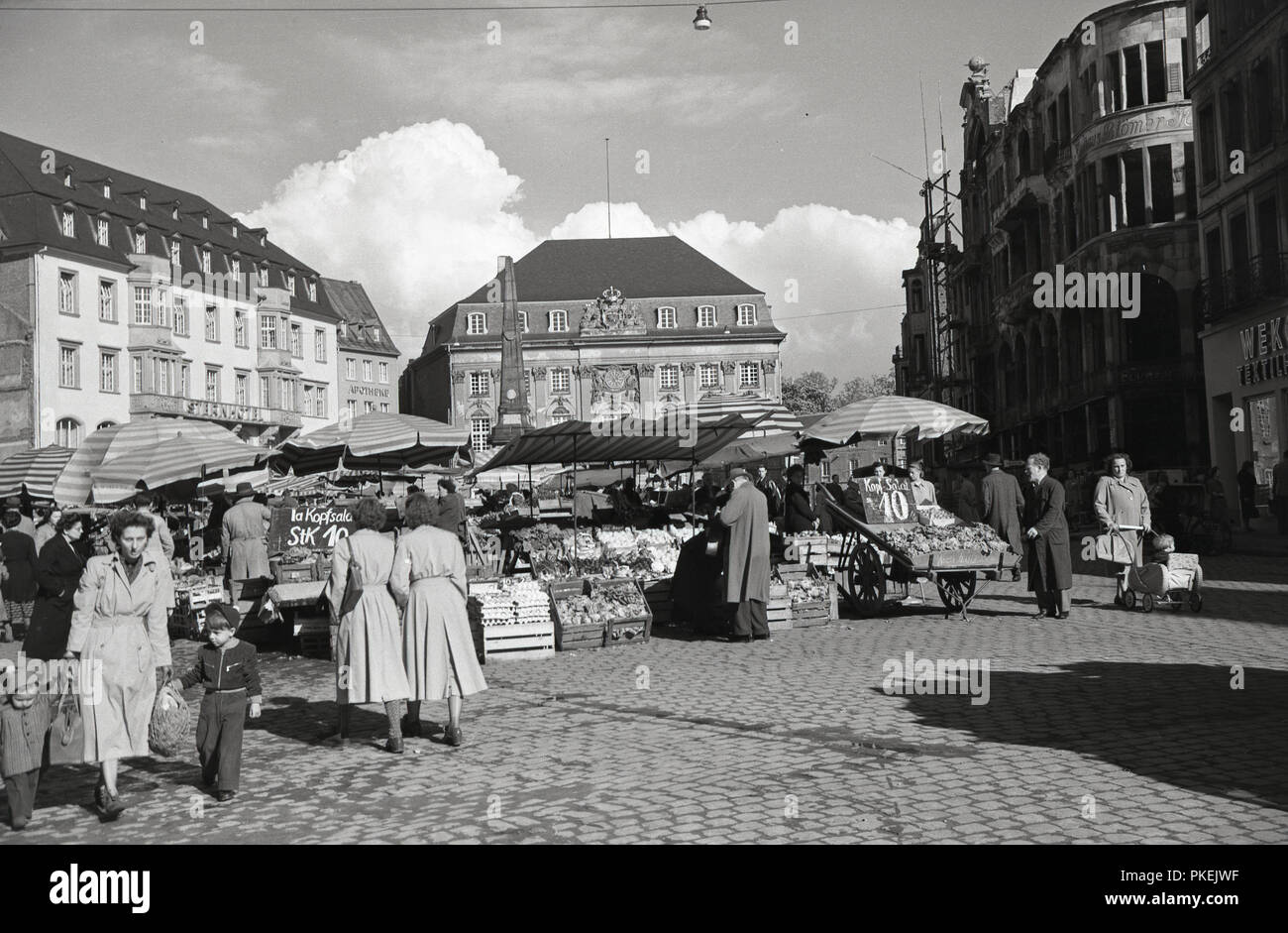 1950, historische, Nachkriegszeit, Käufer an ein Open-air-Markt in einem breiten gepflasterten Straße in Köln, Deutschland. Stockfoto