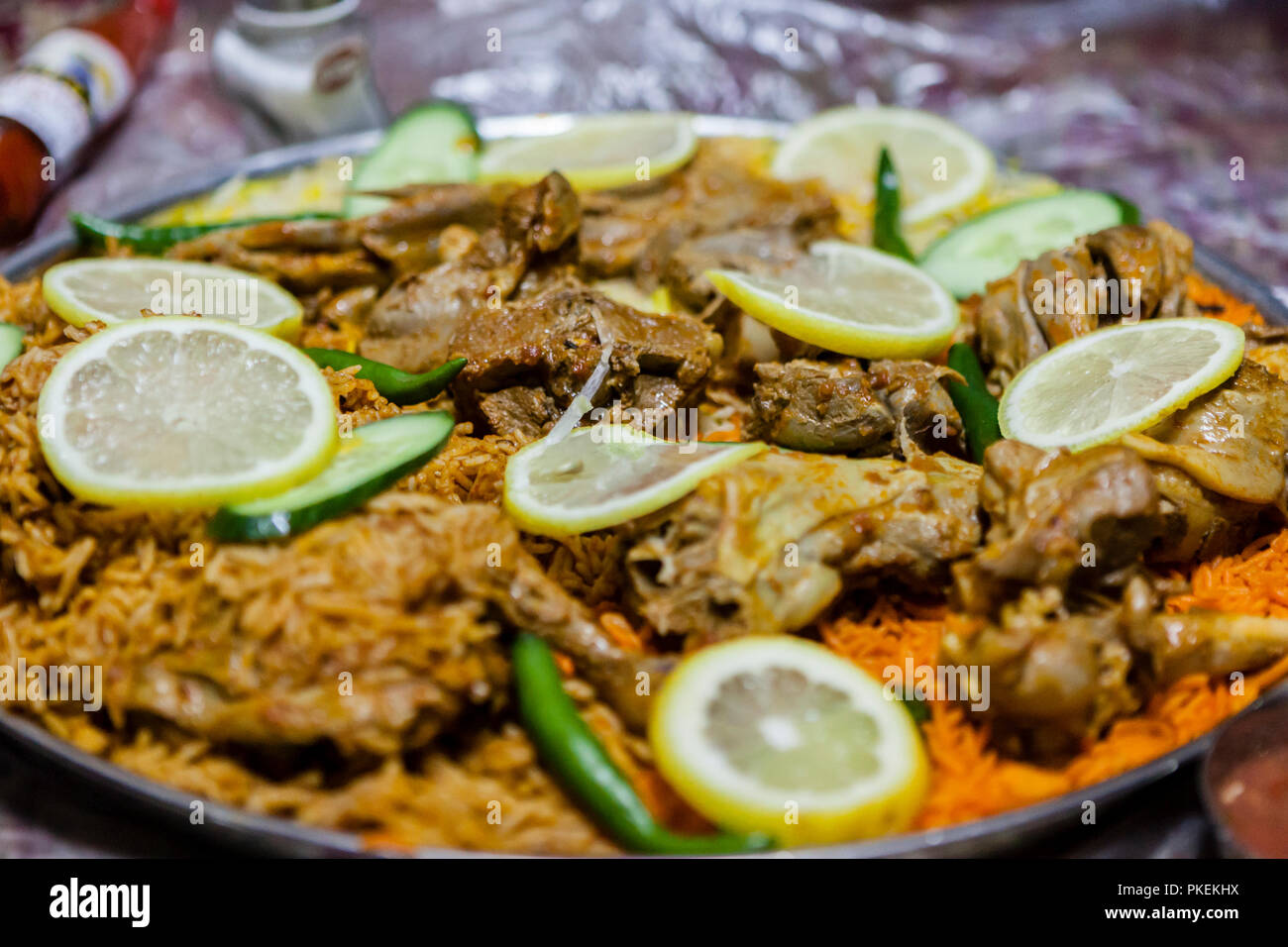 Lamm Salona und Huhn Mandi serviert auf dem Boden in einem Emiratischen Restaurant in Dubai, Vereinigte Arabische Emirate Stockfoto