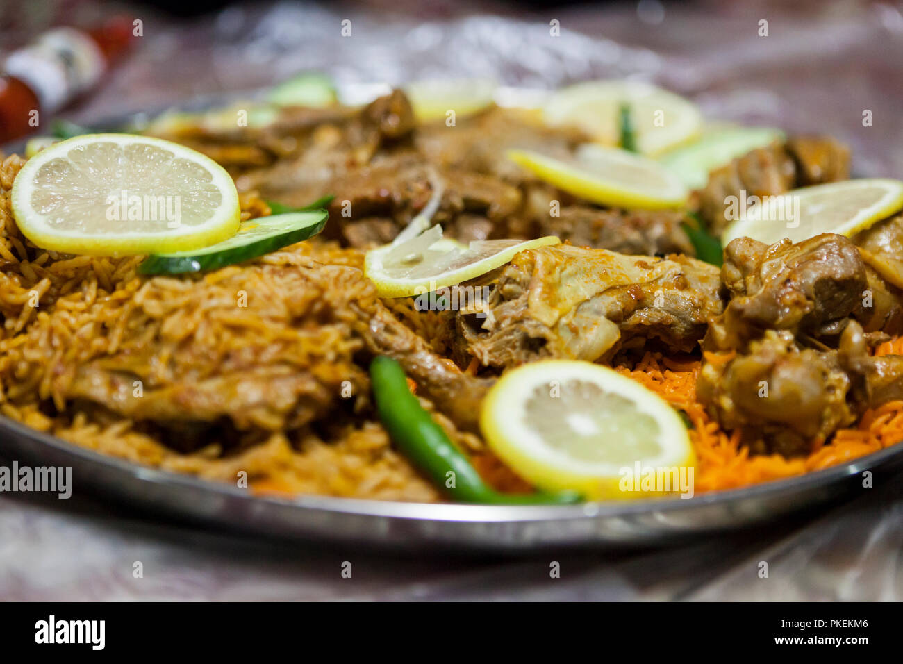 Lamm Salona und Huhn Mandi serviert auf dem Boden in einem Emiratischen Restaurant in Dubai, Vereinigte Arabische Emirate Stockfoto