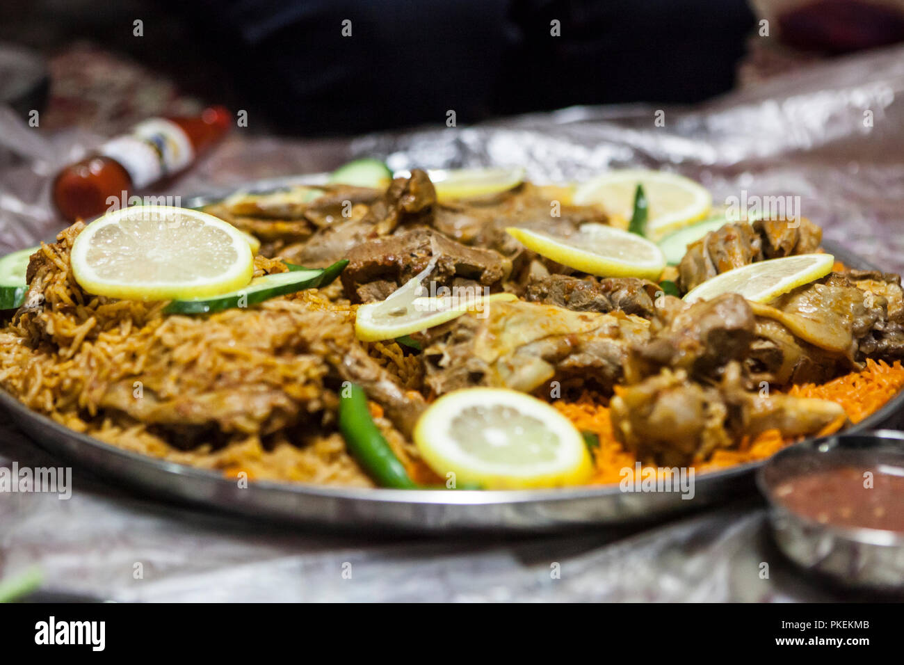 Lamm Salona und Huhn Mandi serviert auf dem Boden in einem Emiratischen Restaurant in Dubai, Vereinigte Arabische Emirate Stockfoto