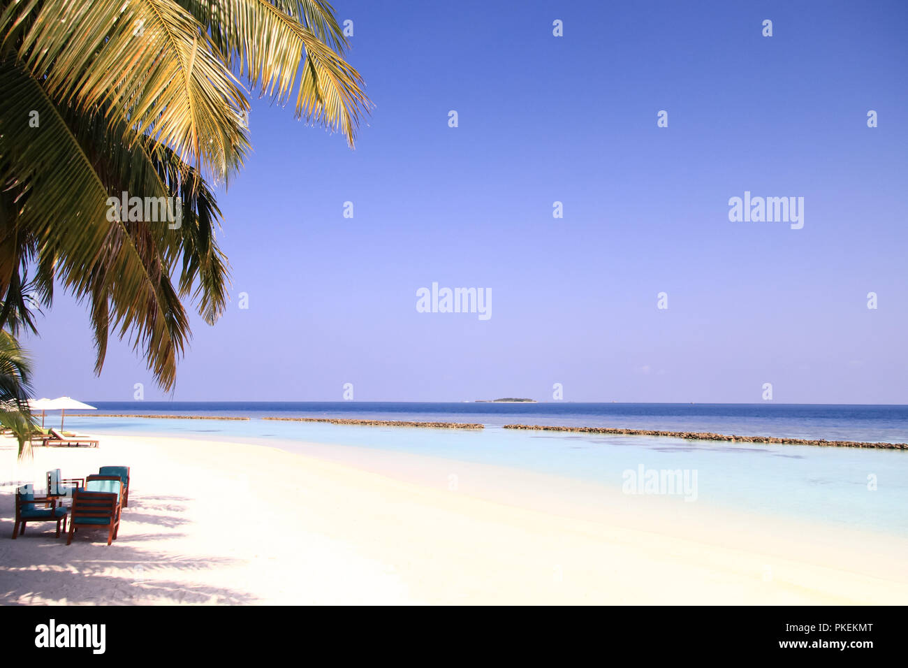 Maledivische Insel Resort und Palmen mit Pazifischen Ozean im Hintergrund Stockfoto