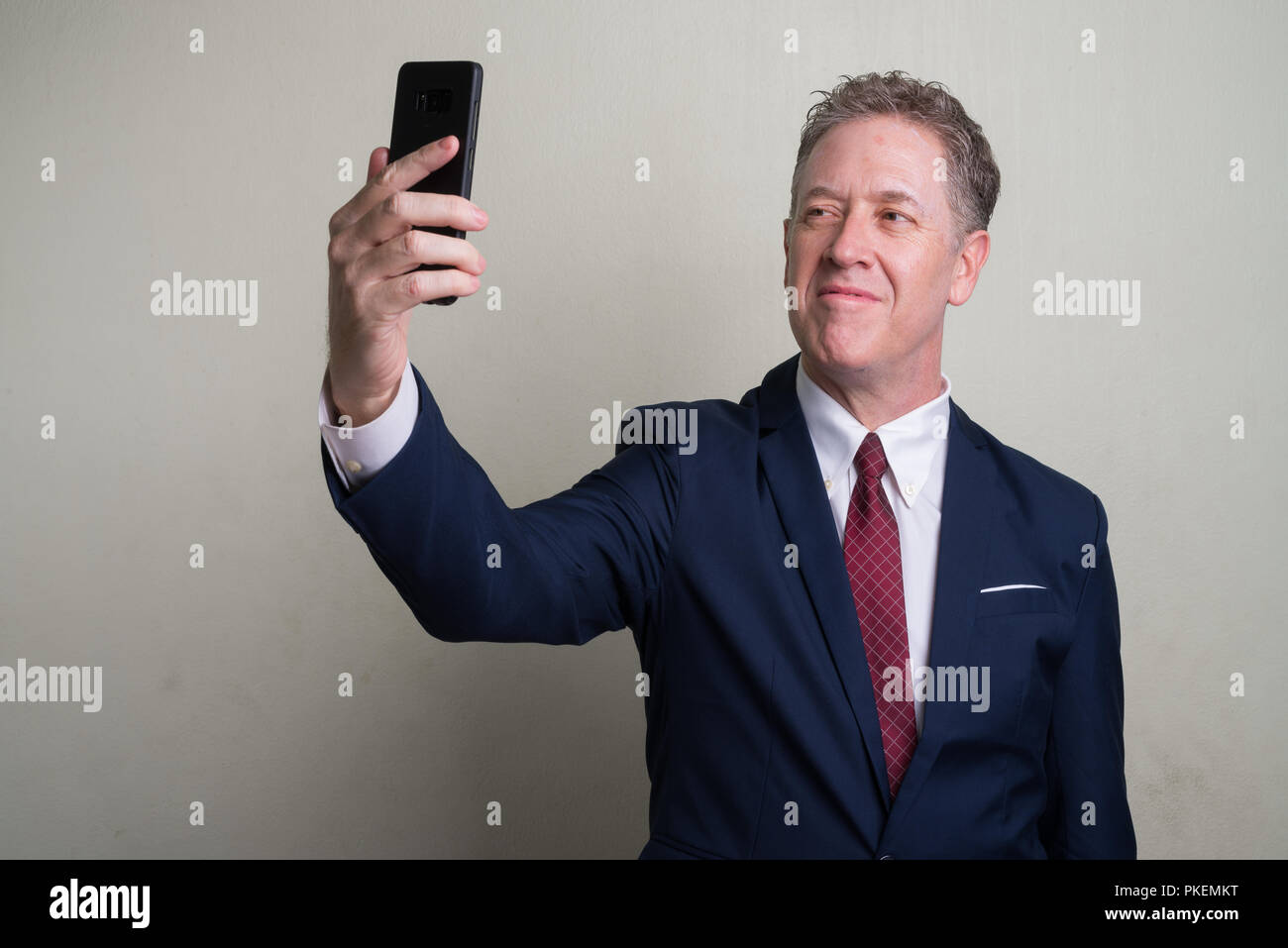Portrait von Reifen Geschäftsmann vor weißem Hintergrund Stockfoto