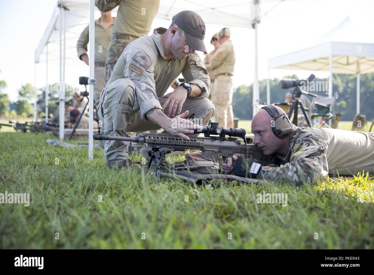 Coast Guard Petty Officer 1st Class Eric Maurer, eine maritime Durchsetzung Spezialist und ein Ausbilder mit der Präzision Treffsicherheit Schule, Tests das Absehen von Petty Officer 1st Class Chris Roberts M 110 Halbautomatische Sniper System, indem Sie seine Hand vor der Anwendungsbereich während der Präzision Treffsicherheit Kurs an der spartanischen Ranch Tactical Training Center, Maysville, Juli 26. Nach Abschluss des vierwöchigen Kurs, der coastguardsmen wird Präzision sportschützen angesehen werden können und die Fähigkeiten, die Sie in das Feld Job gelernt. Stockfoto