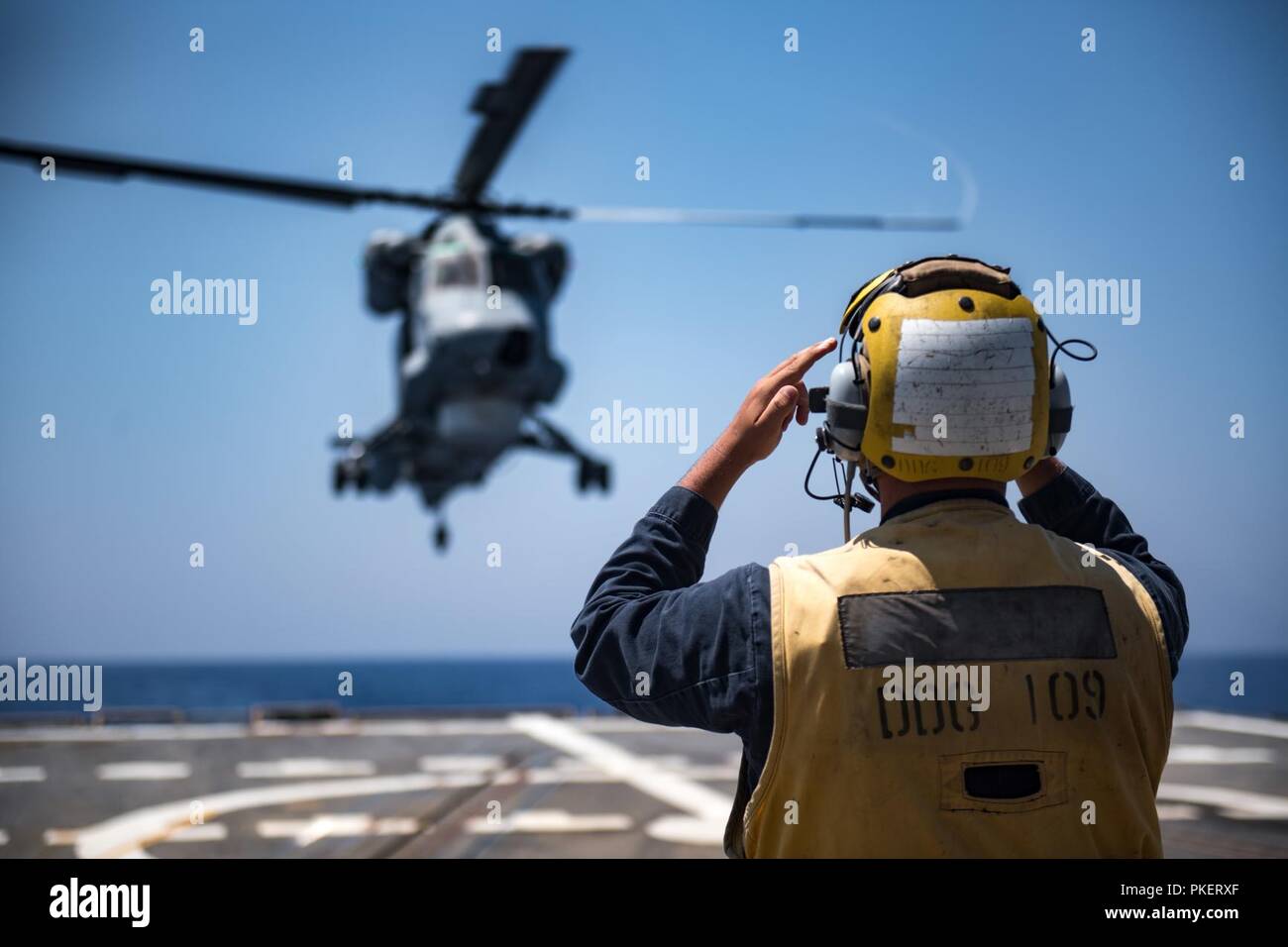 Roten Meer (31. Juli 2018) Der Bootsmann Mate 2. Klasse Christopher Gibson Signale einer ägyptischen Naval Force (ENF) SH-2G Helikopter zu landen auf dem Flugdeck der geführten Anti-raketen-Zerstörer USS Jason Dunham (DDG109) während der Übung Eagle Salute 18. Gruß Eagle18 ist eine Oberfläche Übung mit der Enf durchgeführt, Interoperabilität und Kriegsführung Bereitschaft, Verstärkung der militärischen Beziehungen zu verbessern und die operativen Fähigkeiten von allen Beteiligten voraus. Jason Dunham ist in die USA 5 Flotte Bereich für Maßnahmen zur Erhöhung der Marineoperationen bereitgestellt maritime Stabilität und s zu gewährleisten Stockfoto