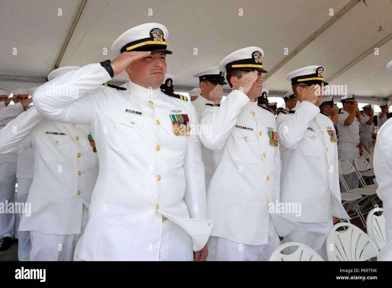 NORFOLK, Virginia (Aug. 1, 2018) Offiziere zu Submarine Squadron Six zugewiesen begrüssen die nationalen Ensign während des U-Boots Squadron 6 Ändern des Befehls an Bord der Virginia-Klasse Angriffs-U-Boot USS Washington (SSN787) in Norfolk, Virginia. Kapitän Martin Muckian entlastet Kapitän Carl Hartsfield als Kommandant, Submarine Squadron Six. Stockfoto