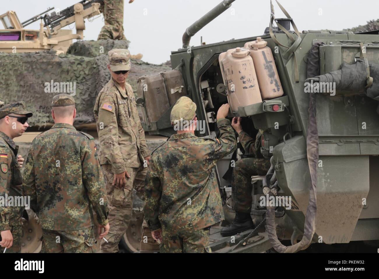 Staff Sgt. Keenan M. Kozak, einem Tank Commander mit dem Fort Hood auf der Grundlage Charlie Company, 2 Squadron, 5th Cavalry Regiment, hört zu Fragen von deutschen Soldaten über die Stryker Fahrzeug vor der Eröffnungsfeier von edlen Partner 18 am Wasiani, Georgien am 1. August 2018. Die US-Armee Europa übung Georgisch, regionale Partner und US-Streitkräfte Bereitschaft und Interoperabilität in eine realistische und anspruchsvolle multinationalen Umfeld verbessern. U.S. Army National Guard Stockfoto