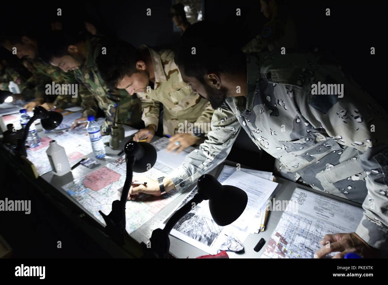 KABUL, Afghanistan (August 1, 2018) --Kommandos mit der Afghan National Army Special Operations Command und Polizei aus dem allgemeinen Befehl der Polizei spezielle Einheit (GCPSU) Zug Schulter-zu-Schulter, Plotten grid Standorte für Nähe Luftangriff auf den Anruf für Brand Simulator an der Afghan National Army Special Operations Command School of Excellence (SOE) Land navigation Specialty Kurs. Dieser Teil des Landes navigation Specialty Kurs ist zwei Wochen lang und in der Nähe von Kabul, Afghanistan statt. (NATO Stockfoto