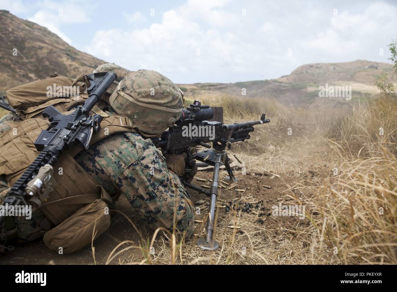 Ein US-Marine machine Gunner mit 3.BATAILLON, 3. Marine Regiment, III Marine Expeditionary Force, feuert eine M240B Maschinengewehr auf Ziele während einer kombinierten Waffen Übung in der Kaneohe Bay Bereich Training Service, Marine Corps Base Hawaii, Aug 3, 2018. Während der Übung, U.S. Marines genutzt Maschinengewehr Unterdrückung und Mörtel Feuer auf simulierten feindlichen Kräfte, während die Infanteristen in Richtung sie angriff. Stockfoto