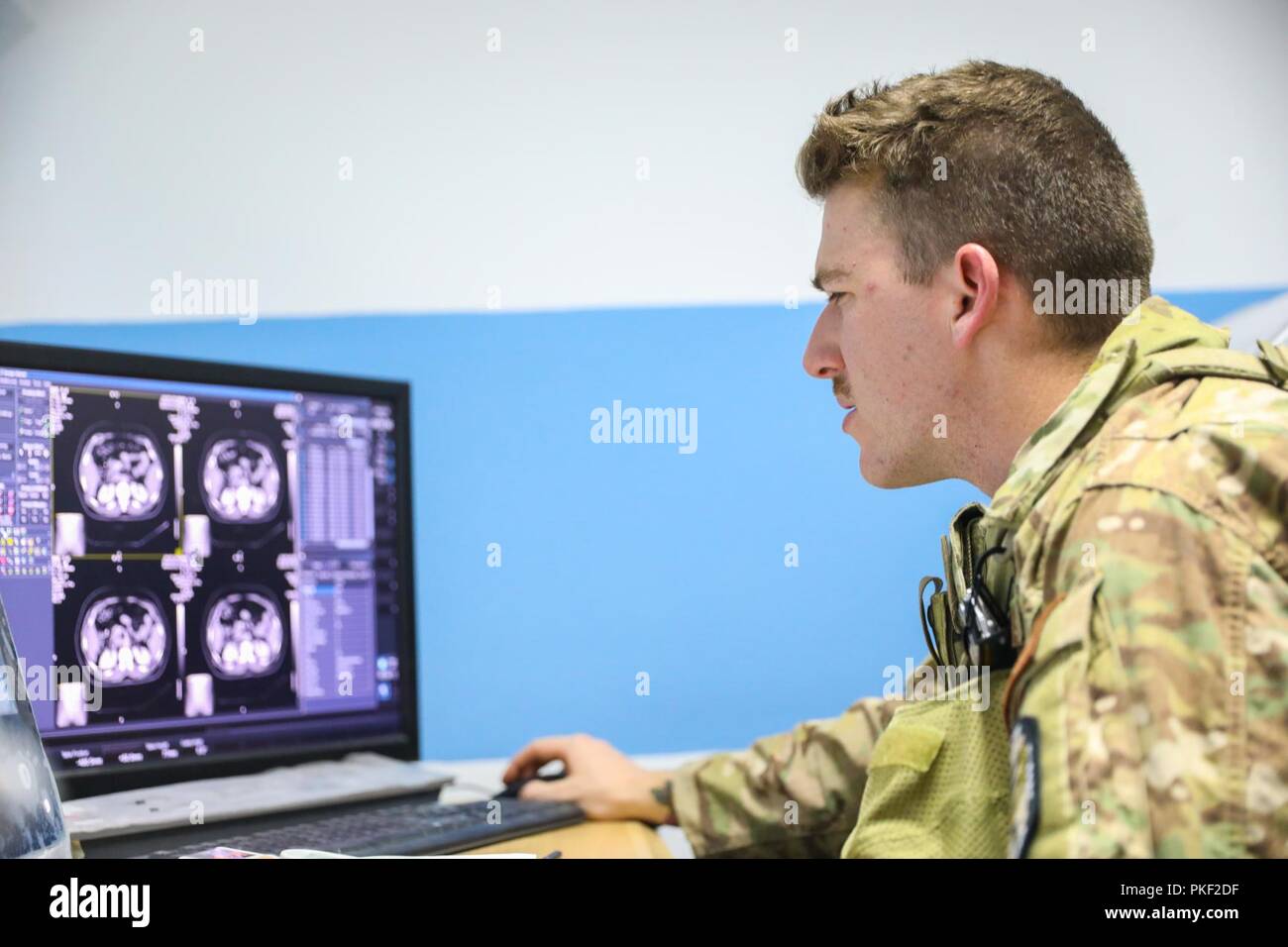 Der PROVINZ KANDAHAR, Afghanistan (5. August 2018) - U.S. Navy Hospital Corpsman 3. Klasse Thomas Fite, eine Radiologie Techniker für Kandahar Airfield Rolle der NATO III Multinationale medizinische Einheit, schaut über Ergebnisse einer x-ray, 5. August 2018, seinem afghanischen Amtskollegen während einer medizinischen Beratung Besuch bei Kandahar regionale militärische Krankenhaus, Camp Held in Kandahar, Afghanistan zu helfen. Mitarbeiter aus der Rolle III Durchführung Routinemäßige Besuche auf KRMH zu trainieren und afghanischen medizinischen Personal beraten. Stockfoto