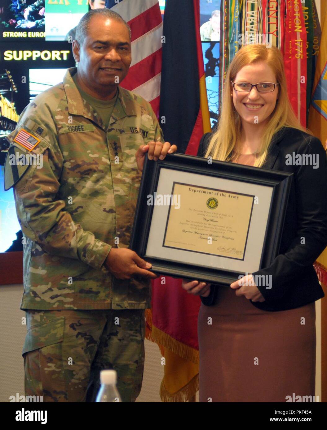 Cheryl Bourne, 21 Theater Sustainment Command Aufsichtsrat Logistik Management Spezialisten, ist die Mittelstufe Logistics Management Specialist Zertifikat von Generalleutnant Aundre F. Piggee, Abteilung der Armee stellvertretender Stabschef, G-4, Juli 25, 2018, am Panzer Kaserne in Kaiserslautern, Deutschland präsentiert. Bourne war die erste Person, die in Europa den Kurs durchzuführen. Stockfoto