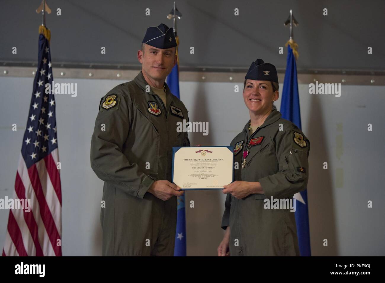 Brig. Gen. Robert Novotny, 57 Wing Commander, präsentiert die Legion des Verdienstes zu oberst Samantha Wochen, 57 Gegner Taktik Gruppe ausgehende Commander, die während eines Befehls Preisverleihung auf der Nellis Air Force Base, Nevada, Aug 8, 2018. Wochen Bewegen der 14 Fighter Training Wing, Columbus AFB, Mississippi zu Befehl. Stockfoto