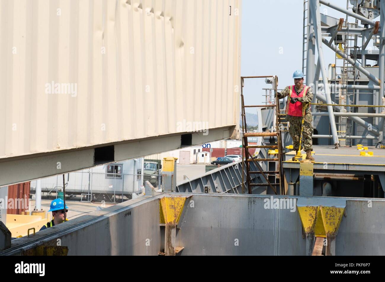 Calif (Aug. 7, 2018) Marine Cargo Handling Bataillon (NCHB) 14 Sailors guide das onload eines Containers an Bord der SS Gem Zustand (T-ACS-2) während einer Übung an der Alten Alameda. NCHB NCHB 5 und 14 zwei-wöchigen regimental Übung bietet die Möglichkeit für Segler gemeinsam in einem Händen zu arbeiten - auf Umgebung, die umfassenden Qualifikationen, erhöhen die Bereitschaft und die Skillsets und Kenntnisse der Matrosen, die Bataillone zu entwickeln. Stockfoto