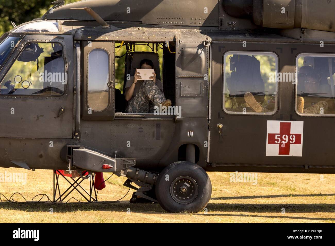 Ein U.S. Army UH-60 Blackhawk Hubschrauber Crew macht Fotos mit Ihrem Tablet während Leapfest 2018 an der Universität von Rhode Island in West Kingston, R.I., Aug 5, 2018. Leapfest ist der größte und am längsten bestehende, internationale statische Linie Fallschirm Training und Wettbewerb veranstaltet vom 56. Truppe den Befehl, Rhode-Island Army National Guard, hohe technische Ausbildung zu fördern und Korpsgeist innerhalb der internationalen Gemeinschaft in der Luft. Über 300 Fallschirmjäger aus neun verschiedenen Ländern werden in diesem Jahr teilnehmen. Stockfoto