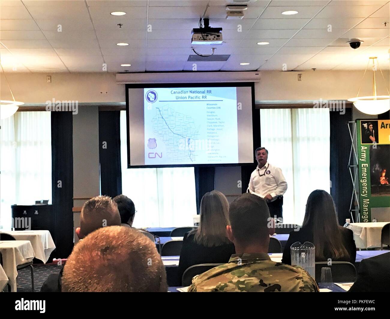 Steve Fenske, Direktor der East Central Region für Wisconsin Emergency Management, Adressen von Teilnehmern zu den 2018 Threat Management Team Meeting Aug 9, 2018, in der McCoy das Gemeindezentrum am Fort McCoy, Wis. Dies war der achte Jahrestagung der Team, an dem auch Menschen aus Fort McCoy sowie Strafverfolgungs-, Sicherheits- und Notfall- Service Agenturen in Wisconsin. Der Zweck der Konferenz und das Team ist die Vernetzung zu erleichtern und das Wissen der Teilnehmer im Bezug auf die verschiedenen möglichen Bedrohungen in der Nation heute zu verbessern. Stockfoto