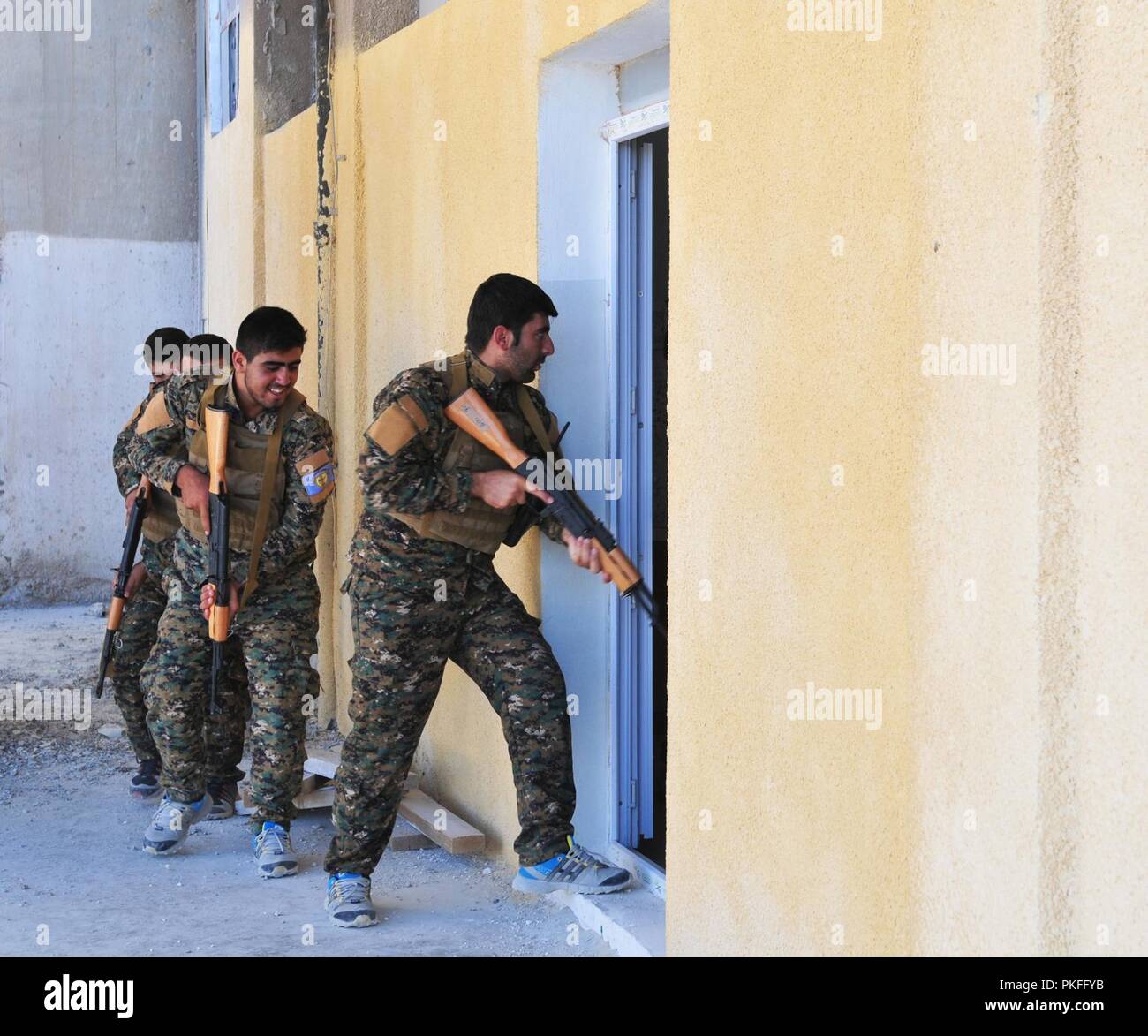 Mitglieder der Manbij militärischen Rat geben Sie ein Zimmer bei einer Bewertung von Close Quarter battle Bohrer in Manbij, Syrien, 10. August 2018. Die Mitglieder der MMC wurden auf ihre Kenntnisse mit Cqb und ihre Fähigkeit, im Team zu arbeiten bewertet. Stockfoto