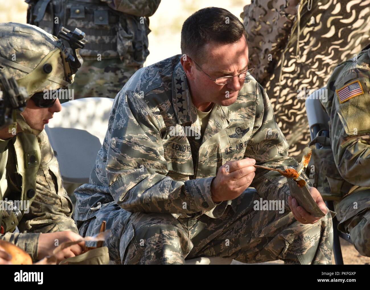 Air Force General Joseph Lengyel, Chief, National Guard Bureau, verbindet der Pennsylvania National Guard Soldaten in Essen, Ready-to-Eat (MRE) am National Training Center in Fort Irwin, Kalifornien, Aug 6, 2018. Pennsylvania National Guard Soldaten der 28.Infanterie Division eine Drehung von Training, wo Einheiten realistischen Bedingungen und entsprechenden entscheidende Maßnahmen Szenarien auf unversöhnliche Gelände konfrontiert. Stockfoto