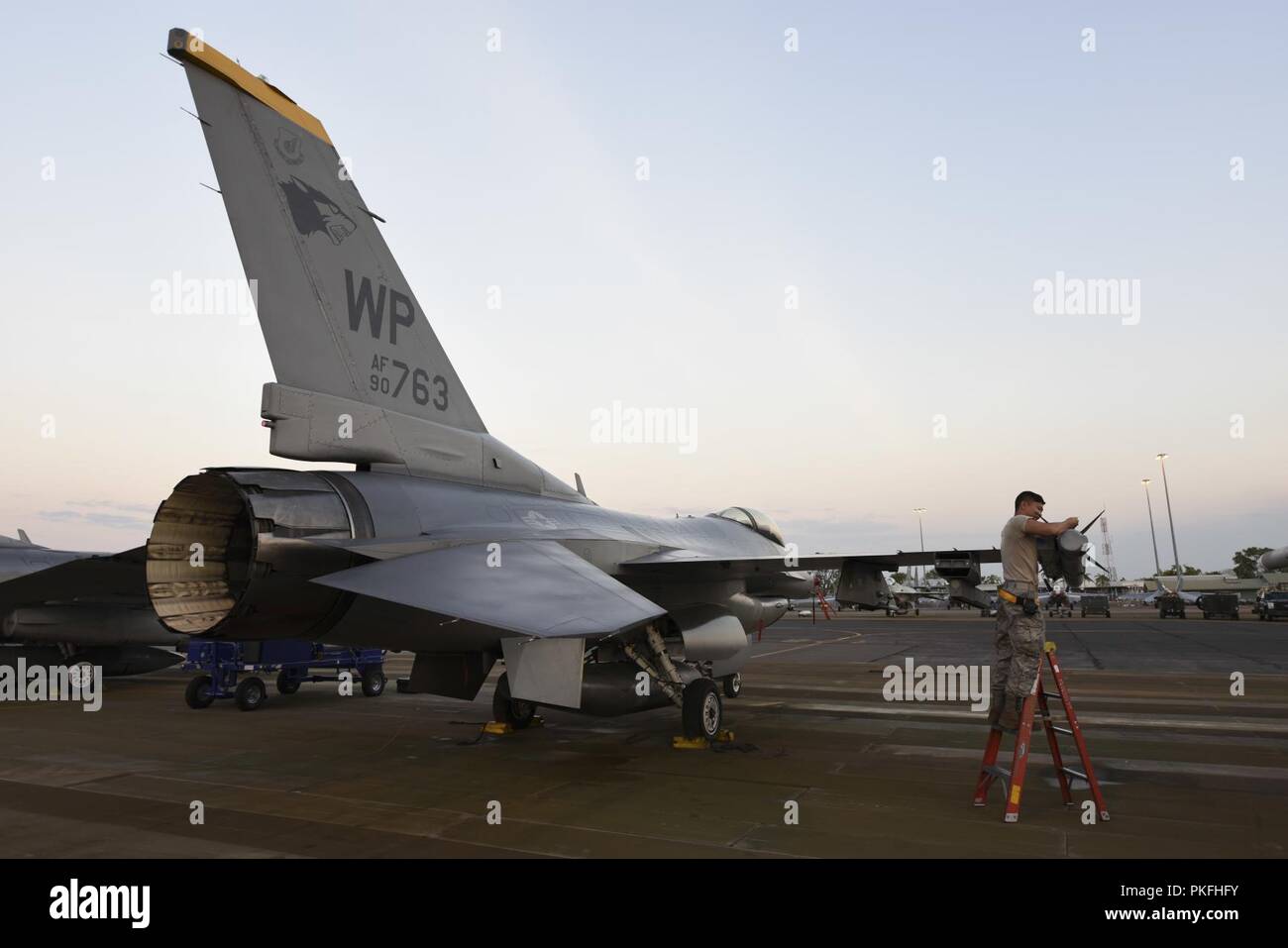 Us Air Force Senior Airman Levi Dimaria, 80 Aircraft Maintenance Unit Waffen laden Crew Chief, führt Wartungsarbeiten an einer F-16 Fighting Falcon vor der Dämmerung während der Übung Pitch Black 2018 Royal Australian Air Force Base Darwin, Australien, 31. Juli 2018. Insgesamt etwa 140 Flugzeuge beteiligen sich Pitch Black 18, US Air Force und US Marine Corps Fighter und Bomber Strahlen zu gehören, Tanken und Drehflügler und der Unterstützung von Bodentruppen. Stockfoto