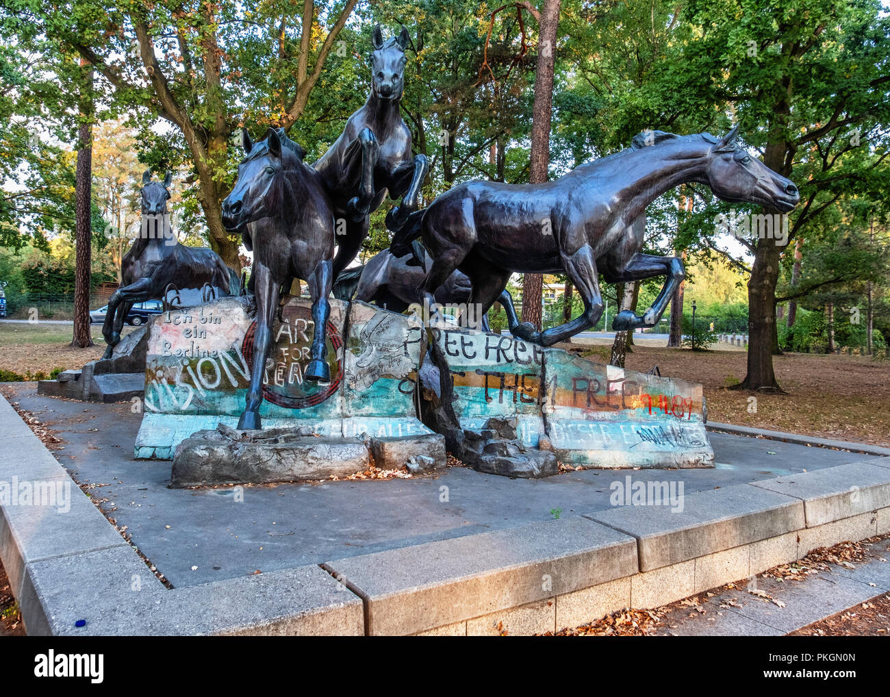 Berlin, Dahlem. Bronze Skulptur von Fünf wilde Pferde über Reste der Berliner Mauer springen. Geschenk aus den USA in die FDR erinnert an den Tag, an dem die Mauer fiel. Stockfoto